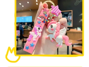 Detail of cute pink unicorn keychain with rainbow silicone strap and gold metal clasp