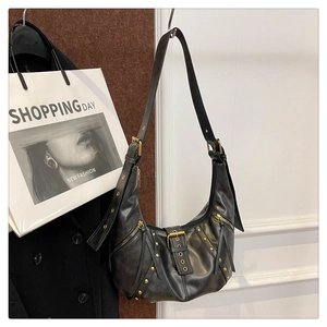 Detail of black leather hobo bag featuring silver studs and wide adjustable shoulder strap