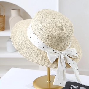 Vue détaillée d'un chapeau de paille pour femmes avec ruban à pois et nœud décoratif