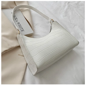 Close-up of cream white hobo bag with crocodile texture and golden zipper detail