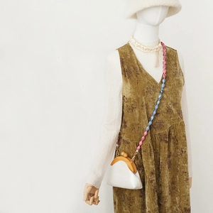 Détail de la bandoulière en perles acryliques colorées sur sac en cuir blanc et bois