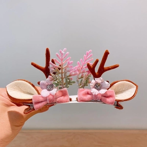Detail of Christmas reindeer antler hair clips with 3D bows and floral accents