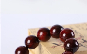Macro detail of polished green sandalwood beads with natural wood grain on vintage box