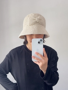 Détail d'un chapeau cloche en coton beige fait main avec un grand nœud décoratif en 3D