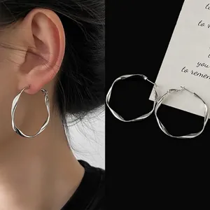 Detail of 4cm silver twisted hoop earrings showing twisted metal texture and worn effect
