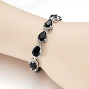Macro detail of teardrop black gemstone bracelet with micro-pave crystals on wrist