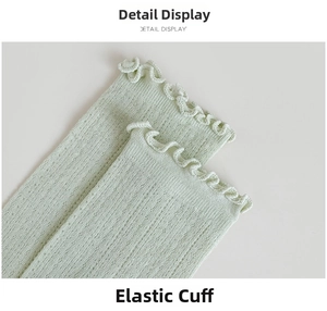 Detail of light green knit socks with elastic ruffle cuffs and pointelle breathable texture