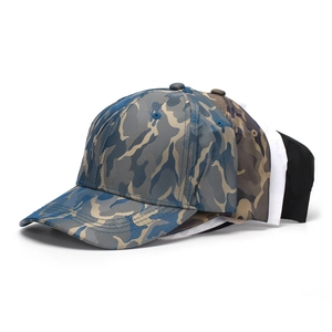Close-up of stacked camouflage baseball caps showing blue and grey camo texture and stitching