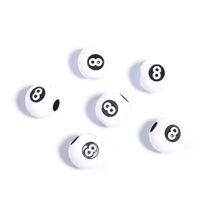 Macro view of white acrylic beads featuring black number eight billiard ball design