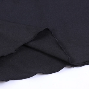 Macro shot of black knitted fabric detailing with wavy ruffled edges and fine textures