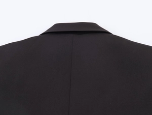 Close-up of the back collar and shoulder seams of a black double-breasted blazer coat