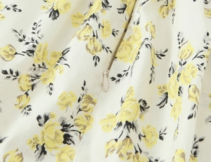 Detailed close-up of invisible zipper on floral poplin midi dress with yellow flower print