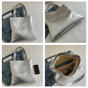 Detail showing crocodile texture and spacious interior of silver tote bag with daily items
