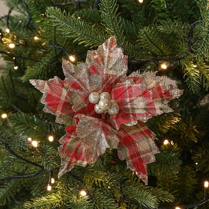 Artificial red plaid Christmas flower with gold glitter decor on festive tree branch