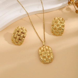 Macro detail of gold jewelry set showing woven texture on rectangular earrings and necklace