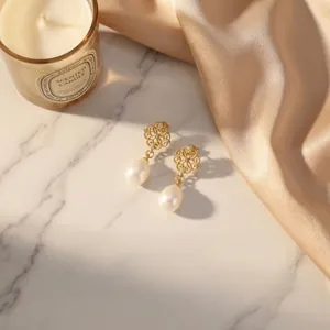 Detailed view of 18K gold-plated earrings with freshwater pearls and intricate filigree
