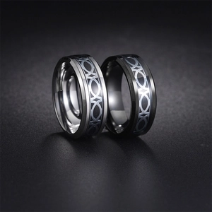 Close-up of silver and black stainless steel rings with geometric celtic knot patterns