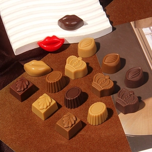 Variety of assorted chocolate-shaped resin charms including lips and crowns on display