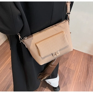 Detailed side view of khaki vertical pleated crossbody bag with golden twist lock buckle