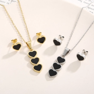 Detailed view of heart-shaped necklace and stud earring sets in gold and silver finishes