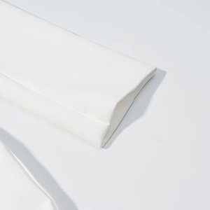 Detail of white dress sleeve showing fine stitching and smooth fabric texture
