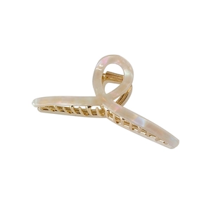 Iridescent cream hair claw clip with gold metal teeth shown from a side angle