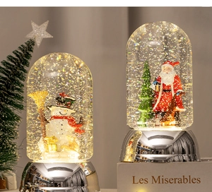 Detailed view of snowman and Santa Claus Christmas snow globes with metallic bases