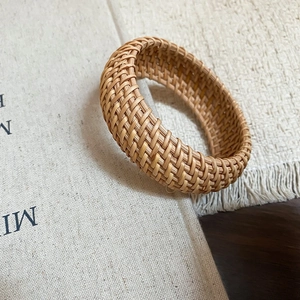 Détail d'un bracelet en rotin tressé à la main au style bohème et texture naturelle