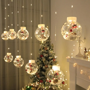 Detail of clear Christmas ball lights featuring miniature Santa figures and warm LED bulbs