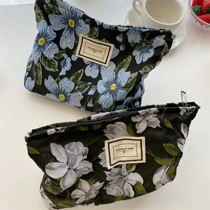 Detailed macro view of vintage floral jacquard makeup pouches with secure zip closure