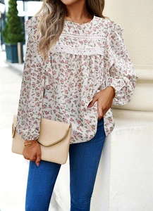 Detail of floral long sleeve blouse with lace trim accents on white fabric base