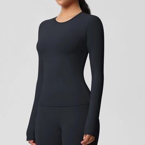 Détail d'un haut de fitness noir à manches longues avec coupe slim et tissu stretch