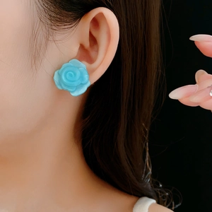 Vue détaillée de boucles d'oreilles roses en résine bleue avec tiges en argent