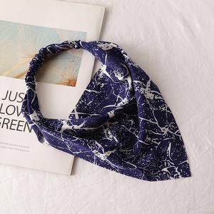 Detail of navy blue tie-dye chiffon bandana with elastic band on botanical magazine