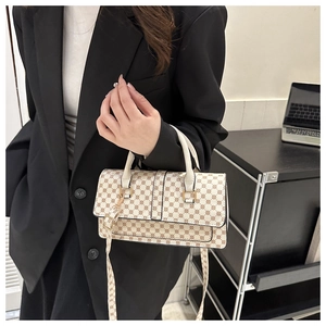 Chic beige crossbody bag with circular patterns held by a model in a black suit