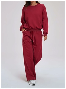 Detail of burgundy crewneck sweatshirt with ribbed cuffs and elastic drawstring pants