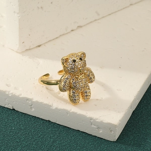 Sparkling gold bear ring with full crystal pavé on a white stone decorative display