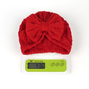 Vue détaillée du bonnet turban rouge pour bébé pesant 43,6g sur une balance numérique