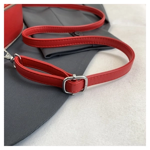 Detail view of red leather shoulder strap with adjustable silver metal buckle and hooks