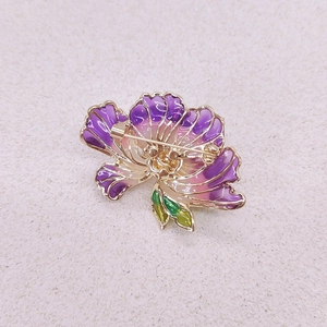 Detail of the golden pin backing and purple enamel flower petals on the brooch