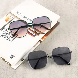 Detail view of retro oversized square cycling sunglasses in green and silver frames