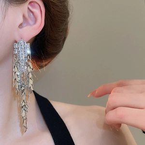 Detail of silver long tassel earrings with sparkling cubic zirconia on a female model