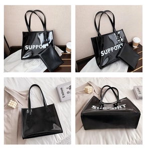 Detail of black glossy tote bag with white SUPPORT lettering and matching inner pouch