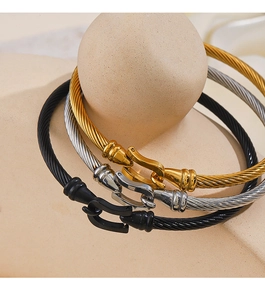 Detailed set of twisted cable wire bracelets with gold, silver, and black horseshoe buckles