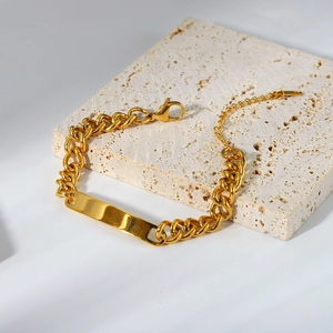 Bracelet gourmette ID en acier inoxydable doré sur pierre de travertin élégante