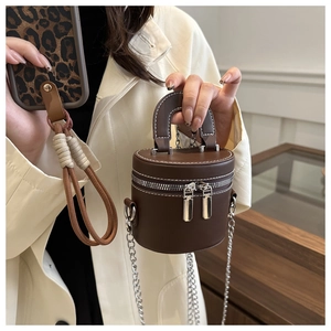 Détail du sac seau marron foncé avec surpiqûres blanches et double fermeture éclair