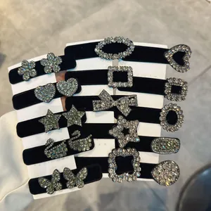 Dettaglio di varie mollette in velluto nero con motivi in strass brillanti e forme