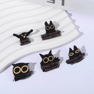 Set of five black enamel cat and owl badges with witty quotes on a white pedestal