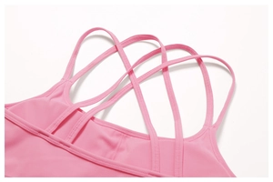 Detail of pink sports bra featuring multi-strap cross-back design and high-stretch fabric