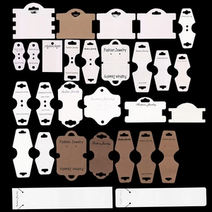 Detailed collection of assorted white and kraft paper jewelry display cards on black background